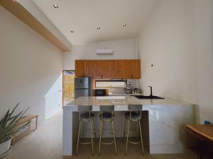 une cuisine avec un îlot et des tabourets de bar dans l'établissement Beach front villa, à Mae Haad
