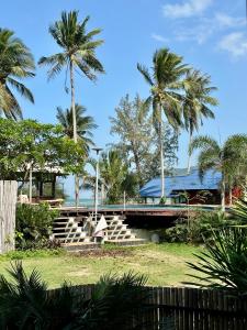 un bâtiment avec des palmiers et des escaliers dans un parc dans l'établissement Beach front villa, à Mae Haad