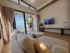 un salon avec un canapé et une vue sur l'océan dans l'établissement Beach front villa, à Mae Haad