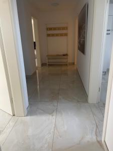 Un pasillo vacío con suelo de baldosas en una casa. en Sunshine FeWo, en Rust