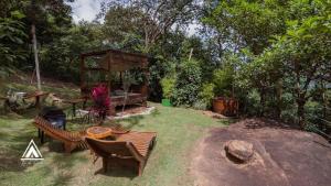 un jardín con banco, mesa y parrilla en Teepee - Tipi da Serra, en Brumadinho