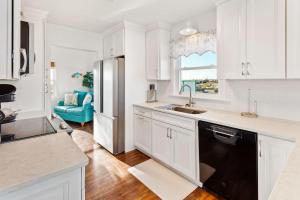 a kitchen with white cabinets and a black dishwasher at 6205 - Markel in Whalebone +38 photos