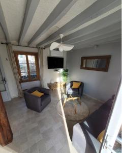 een woonkamer met banken, een tafel en een tv bij Echappée verte et jacuzzi proche de Paris in Vert-le-Grand