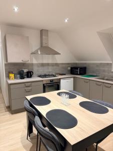 a kitchen with a wooden table with chairs in it at Carpe Diem in Ath