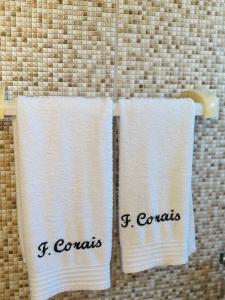 two white towels hanging on a towel rack at Fonte dos Corais - Suíte Onda do Mar in Maragogi