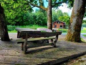 A&G SoDYBA LIUXAPARTAMENT في بلونج: مقعد خشبي على سطح خشبي به أشجار