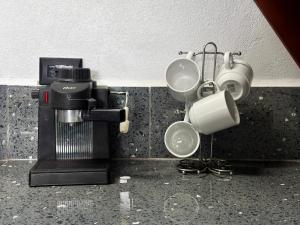 uma cozinha com 2 chávenas e comodidades para preparar café em Cozy Studio with private tropical forest em Tanque mais 12 fotografias