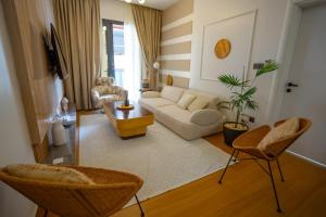 a living room with a white couch and chairs at Résidence LOBOS by Ilios in Dakar