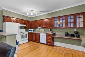 een keuken met houten kasten en witte apparatuur bij Midstream Flat 2BR Wi-Fi Parking in St. John's