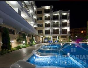 ein Hotel mit einem Swimmingpool vor einem Gebäude in der Unterkunft Villa Valencja Apartments in Sonnenstrand