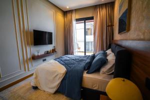 a bedroom with a bed with blue sheets and a window at Résidence LOBOS in Dakar