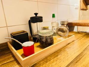 a wooden tray with jars of food on a kitchen counter at Cabaña Alto del Bosque in Coñaripe +19 photos