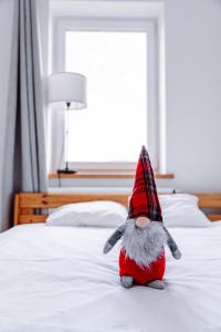a stuffed animal wearing a hat sitting on a bed at Halna Residence in Krynica Zdrój