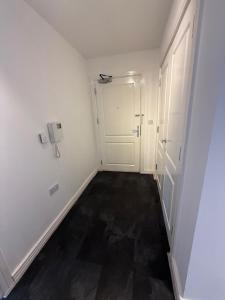een hal met een deur en een telefoon aan de muur bij Modern flat in Abbey Wood in Abbey Wood +4 foto's