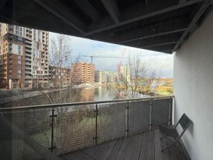 een balkon met een bank en uitzicht op een rivier bij Modern flat in Abbey Wood in Abbey Wood