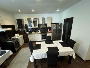a kitchen with a table with chairs and a white and black kitchen at Promenada House Craiova in Craiova