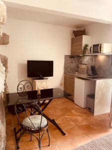 un soggiorno con un tavolo e una cucina di Medieval Studio St Eloi a Le Castellet