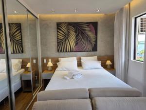 a bedroom with a large white bed and a couch at Luxurious Flat at Lake Side with lake view. in Brasília +46 photos