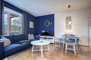 een woonkamer met een blauwe bank en een tafel bij Fewo Henri in Zempin
