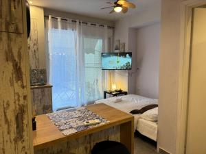 a bedroom with a bed and a tv on the wall at Seaside Escape in Athens
