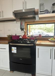 cocina con fogones negros en Cabañas Alto del Bosque, en Coñaripe 13 fotos más