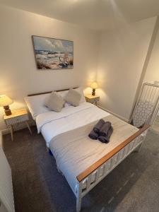 a bedroom with a large bed with towels on it at Relaxing Coastal Flat, Perfect Location in Southbourne