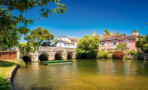 a boat in a river in front of a bridge at Relaxing Coastal Flat, Perfect Location in Southbourne