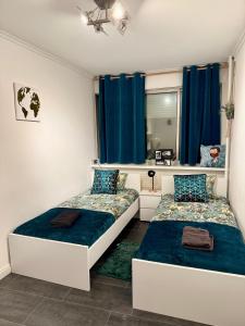 a bedroom with two beds and a mirror at Grand appartement 2 chambres 5 pers max, vue panoramique avec parking in Mulhouse