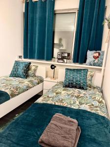 a bedroom with two beds and a mirror at Grand appartement 2 chambres 5 pers max, vue panoramique avec parking in Mulhouse