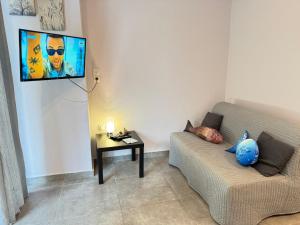 a living room with a couch and a tv on the wall at Seaside Escape in Athens