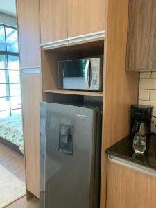 キトにあるSunlight Cumbayaの冷蔵庫と電子レンジ付きのキッチン