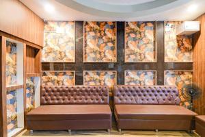 Una sala de espera con un banco de cuero frente a una pared con un mural. en Hotel O GALAXY, en Jagatpur 25 fotos más