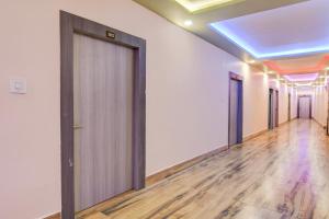 Un pasillo vacío con puertas y suelos de madera. en Hotel O GALAXY, en Jagatpur