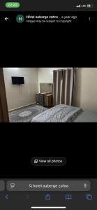 a picture of a bedroom with a bed and a television at Rose du Désert in Atar