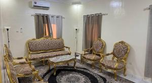 a living room with two chairs and a table at Rose du Désert in Atar