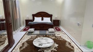 a bedroom with a bed and a table in it at Rose du Désert in Atar