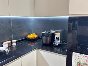 a kitchen counter with a coffee maker and a bowl of fruit at TwinSeas in Draç