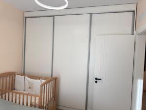 a bedroom with a sliding glass door with a crib at TwinSeas in Draç