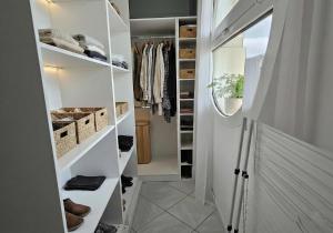 a walk in closet with white shelving at Le Sky - Penthouse d'Exception avec Vue Panoramique et Terrasse en Plein Cœur d'Orsay Paris-Saclay in Orsay +11 photos