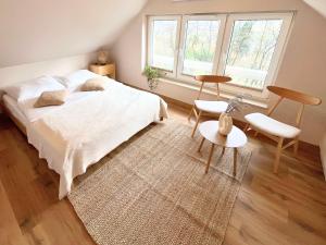 a bedroom with a white bed and a window at Domek przy czerwonym szlaku - The Red Trail Cabin in Węgierska Górka