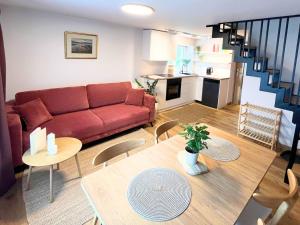 a living room with a red couch and a table at Domek przy czerwonym szlaku - The Red Trail Cabin in Węgierska Górka