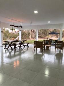 a large room with tables and chairs and an umbrella at Chácara Segredo in Bonito
