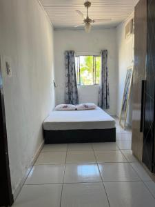 Casa 50 metros da praia mansa في بونتال دو بارانا: غرفة نوم بها سرير في غرفة بها نافذة