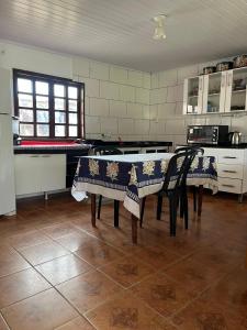 Casa 50 metros da praia mansa في بونتال دو بارانا: مطبخ فيه طاولة وكرسيين
