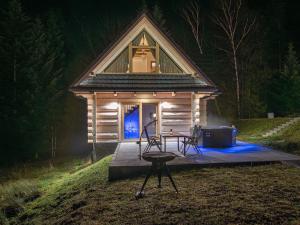 Zielone Wzgórze Sidzina في Sidzina: كابينة صغيرة أمامها طاولة وكراسي +7 صور