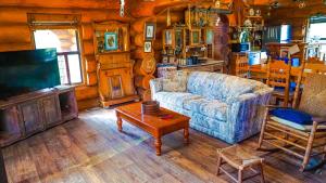 een woonkamer met een bank en een tv bij Blue River Inn. Com in Tishomingo