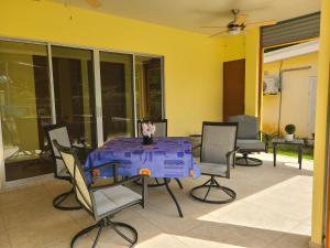 Pura Vida - Villa Lisa في باريتا: طاولة مع قطعة قماش أرجوانية على الفناء