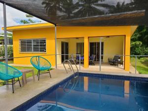 Pura Vida - Villa Lisa في باريتا: فيلا مع مسبح وكرسيين