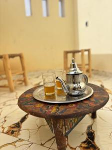 a tea kettle and a glass on a table at Breeze surf lodge in Tamraght Ouzdar