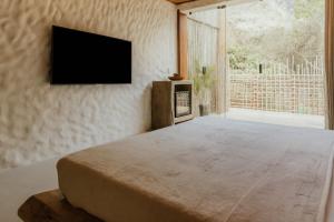 una camera da letto con un letto e una TV a schermo piatto di Villa Milos a Fernando de Noronha